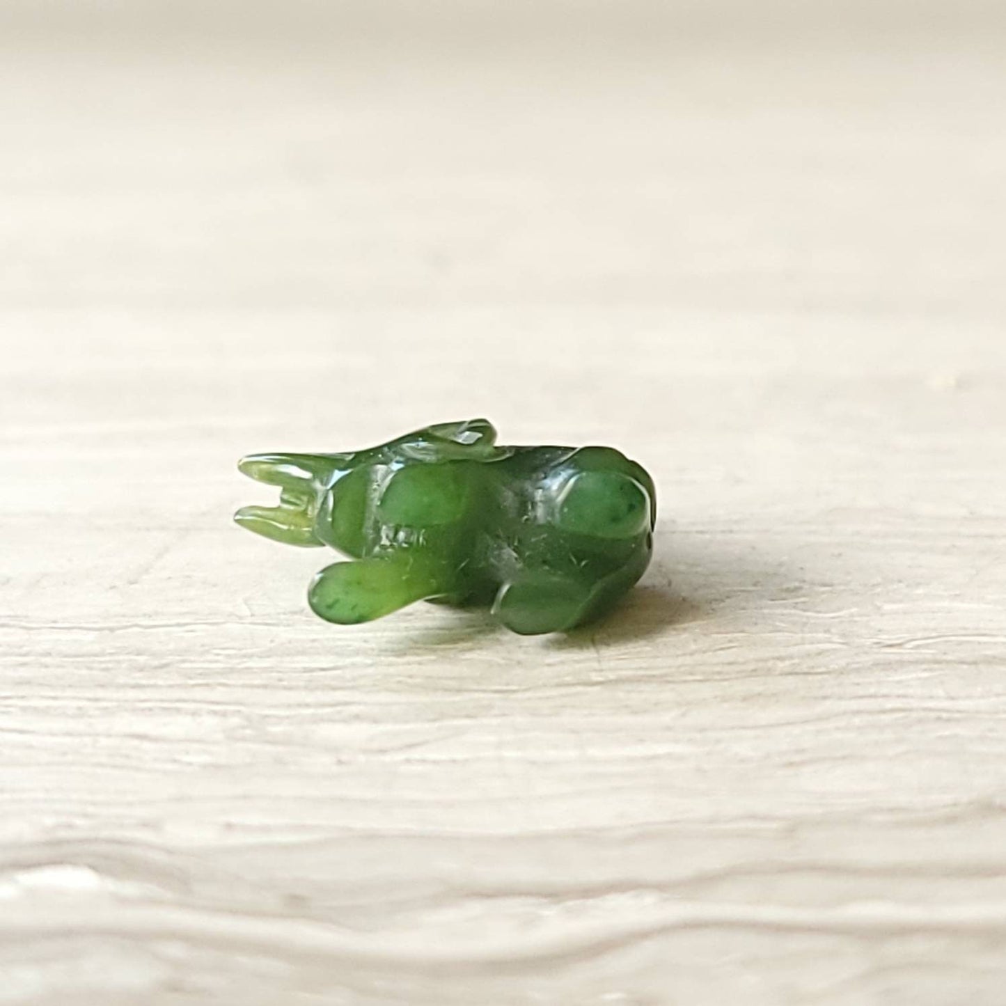 A genuine jade elephant charm hand-carved from nephrite jade, displayed on a sterling silver rolo chain.