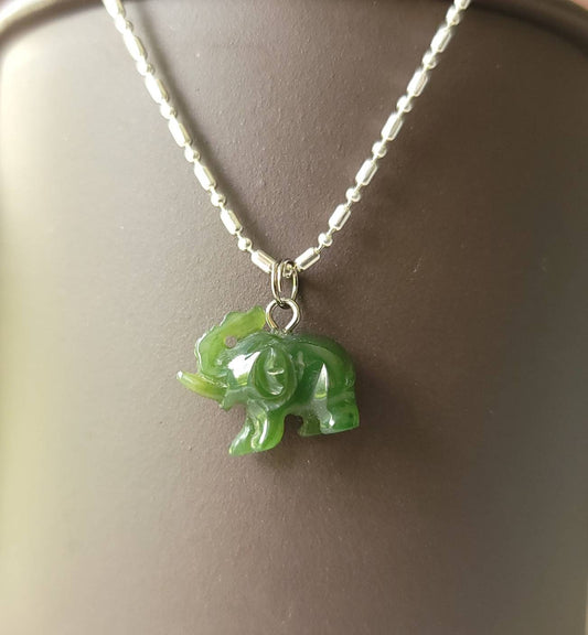 A genuine jade elephant charm hand-carved from nephrite jade, displayed on a sterling silver rolo chain.