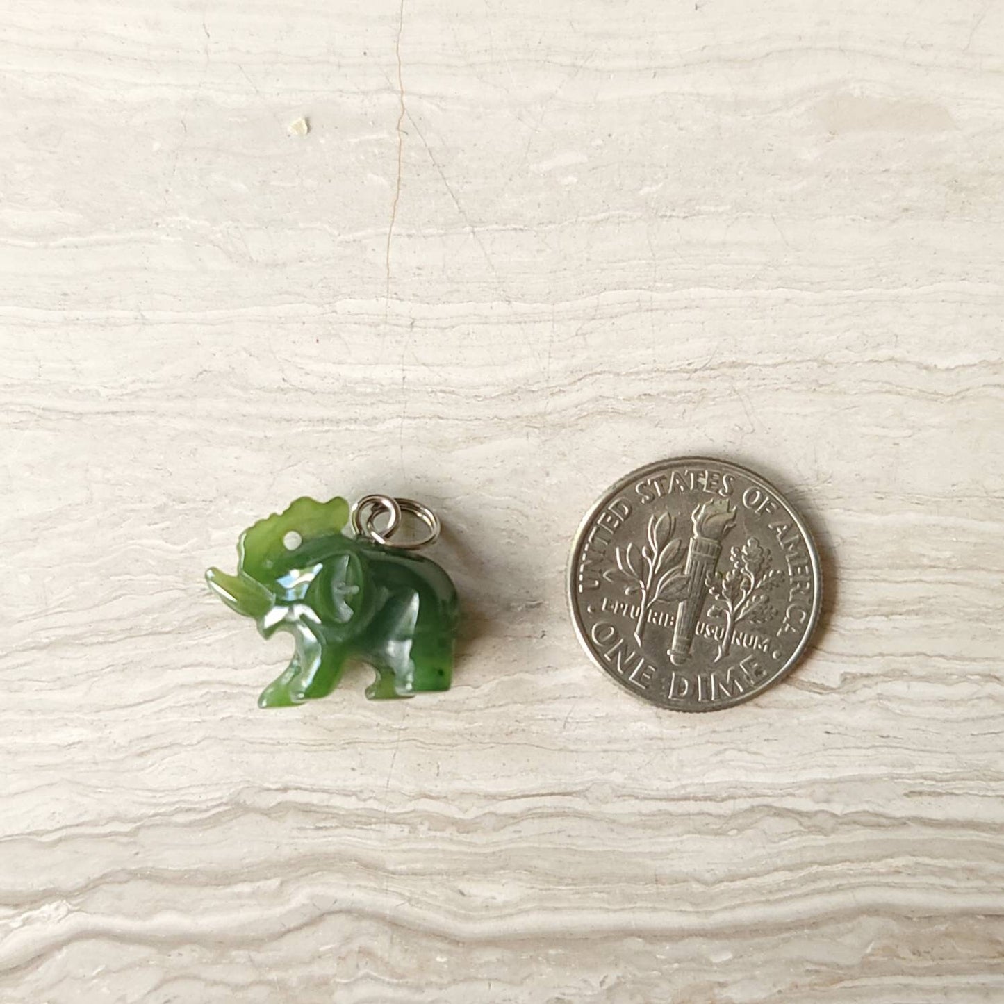 A genuine jade elephant charm hand-carved from nephrite jade, displayed on a sterling silver rolo chain.