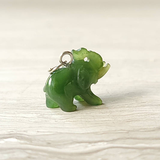 A genuine jade elephant charm hand-carved from nephrite jade, displayed on a sterling silver rolo chain.