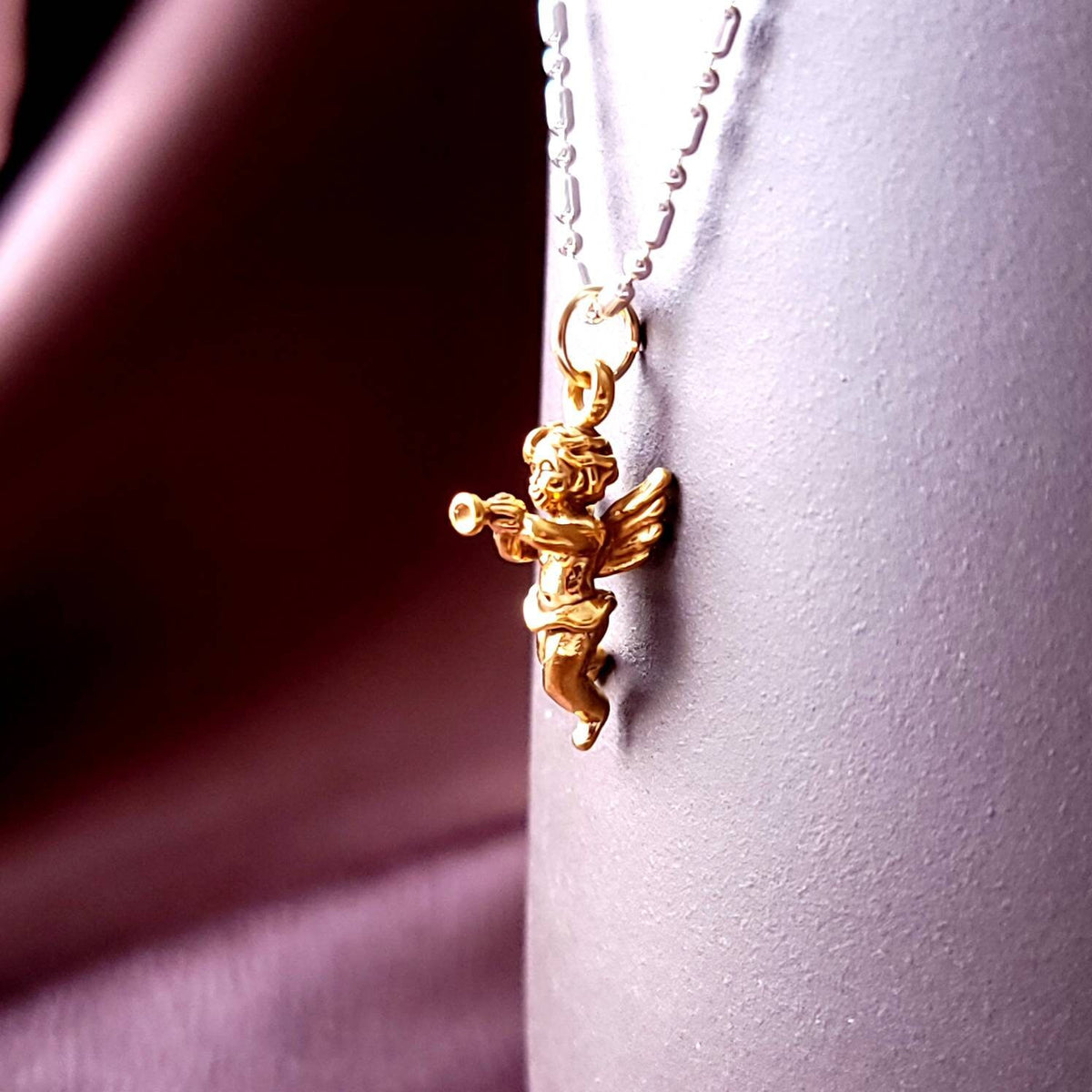 gold cupid charm on a bar and bead chain