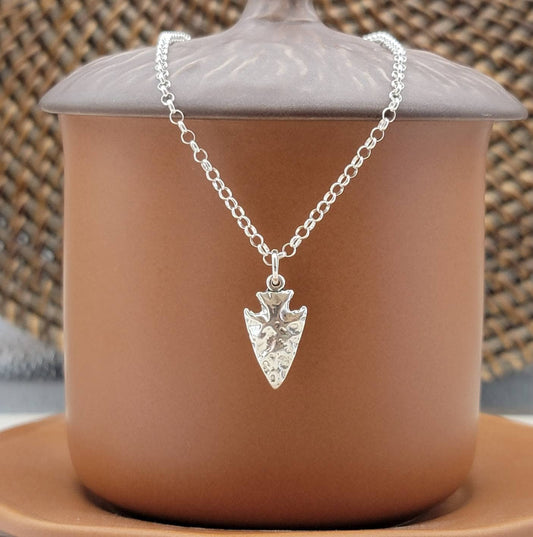 silver arrowhead charm with a shiny finish