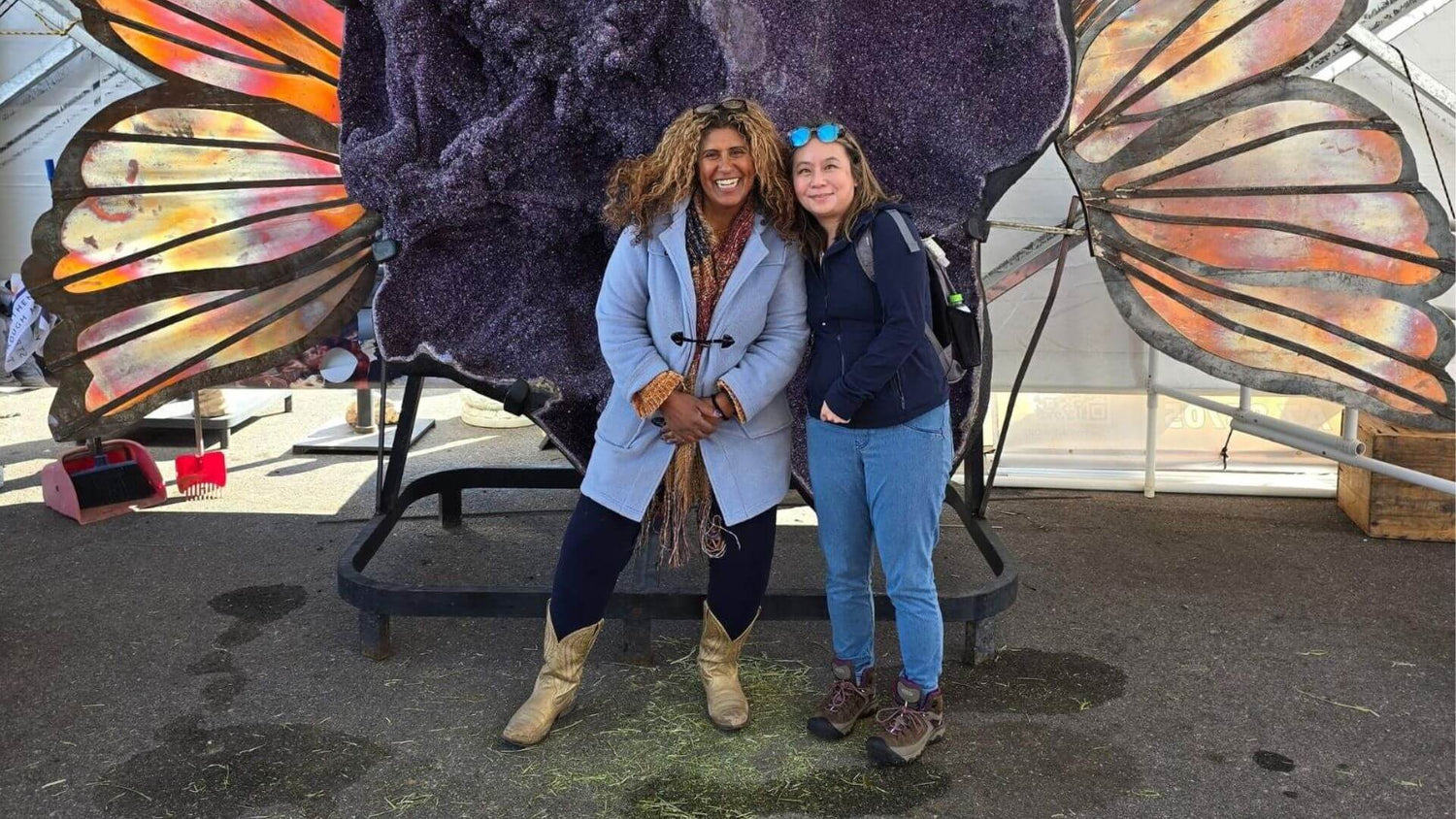 Two people standing in front of a large butterfly Amethyst Geode